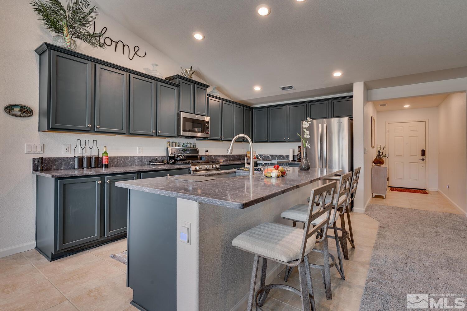 148 Carson River Drive Dayton, NV 89403 - Photo 7 of 31 a kitchen with stainless steel appliances granite countertop a refrigerator a stove a sink and a microwave
