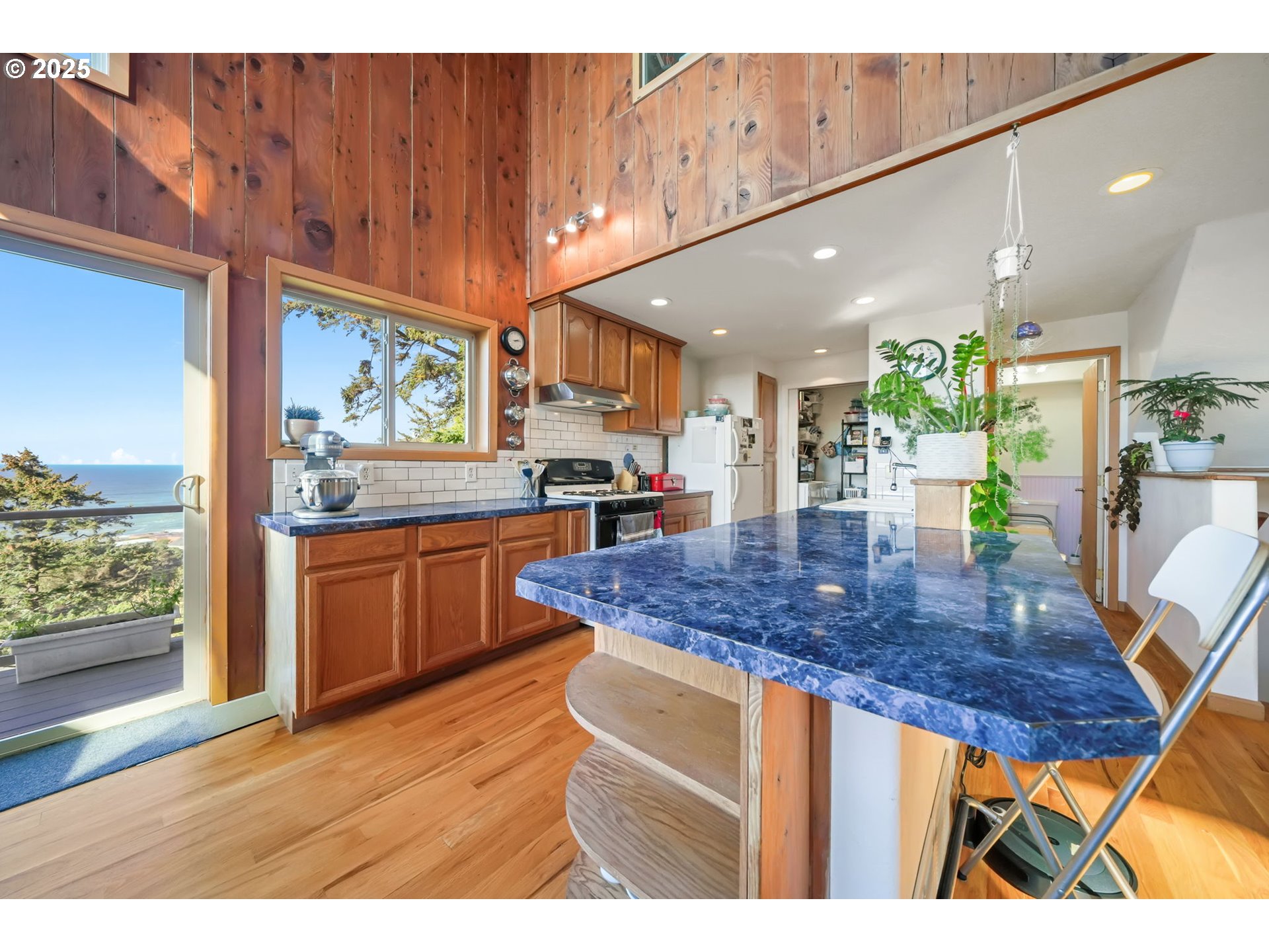 674 Pacific View Drive Yachats, OR 97498 - Photo 23 of 47 a kitchen with stainless steel appliances kitchen island granite countertop a table chairs in it and wooden floor