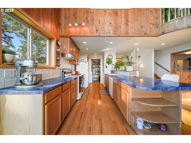 a kitchen with stainless steel appliances granite countertop a stove a sink dishwasher and cabinets with wooden floor