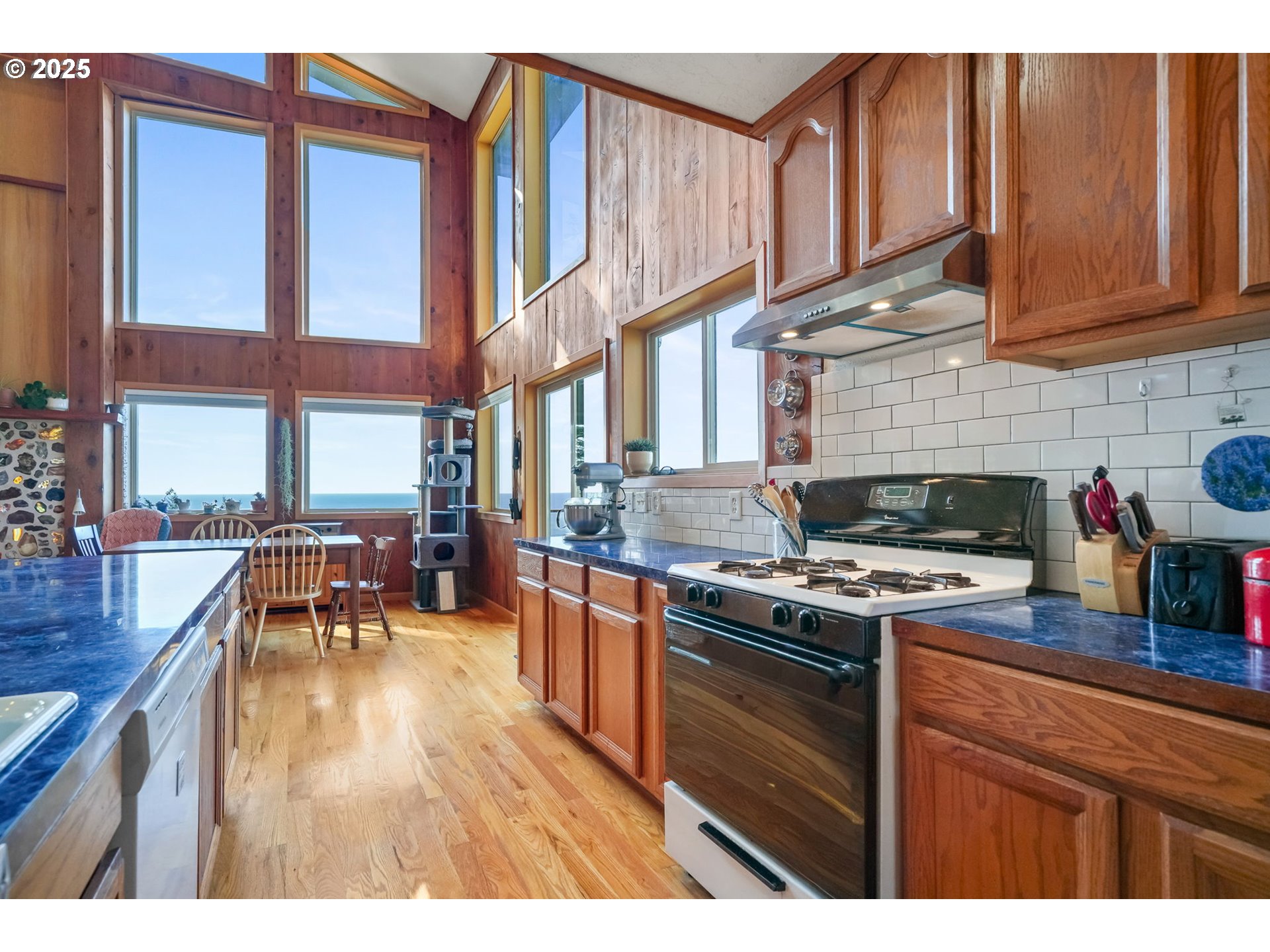 674 Pacific View Drive Yachats, OR 97498 - Photo 25 of 47 a kitchen with stainless steel appliances granite countertop a stove a sink dishwasher and cabinets with wooden floor