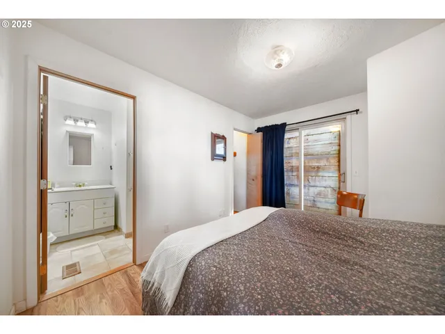 a bathroom with a toilet sink vanity granite and shower