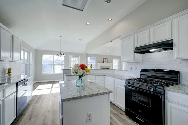 a kitchen with a sink stove and cabinets