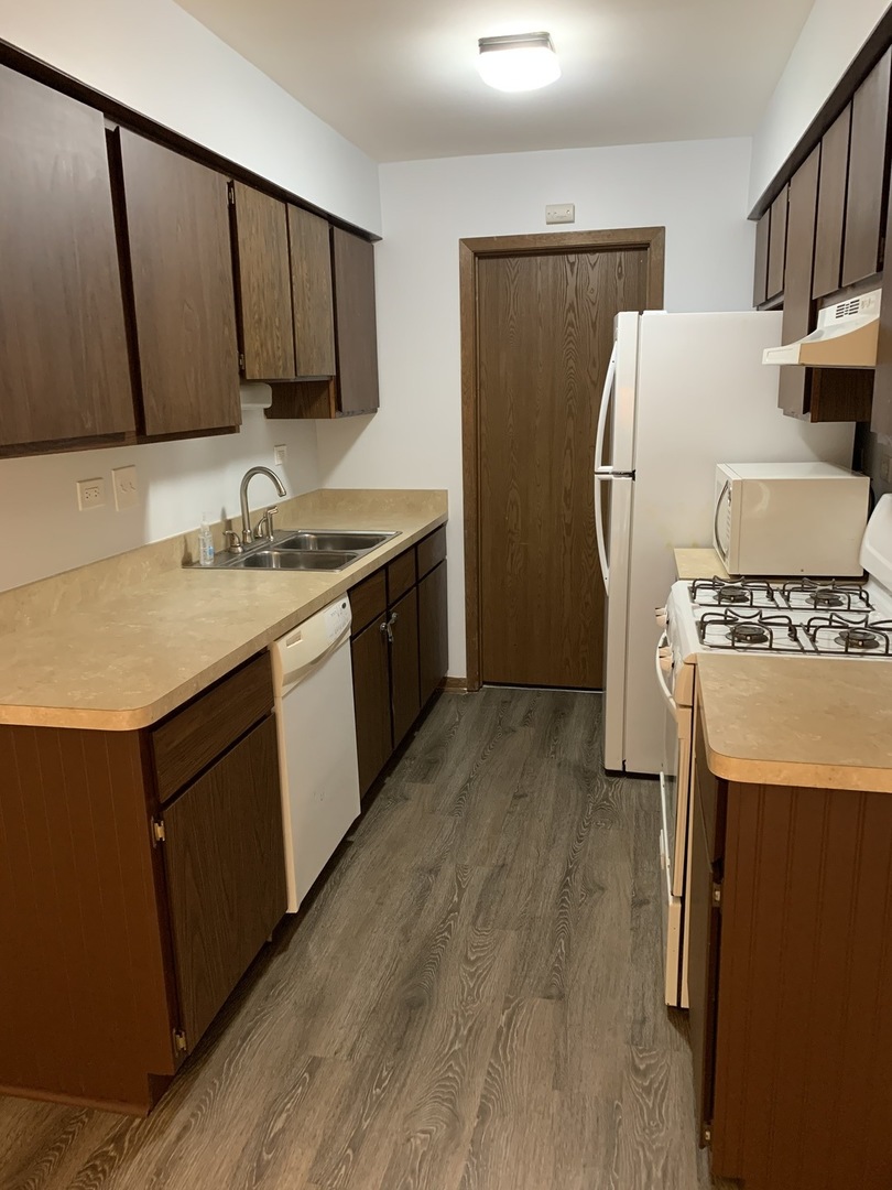 7 Red Barn Road, Unit 107 Matteson, IL 60443 - Photo 5 of 15 a kitchen with a sink a refrigerator and a stove top oven