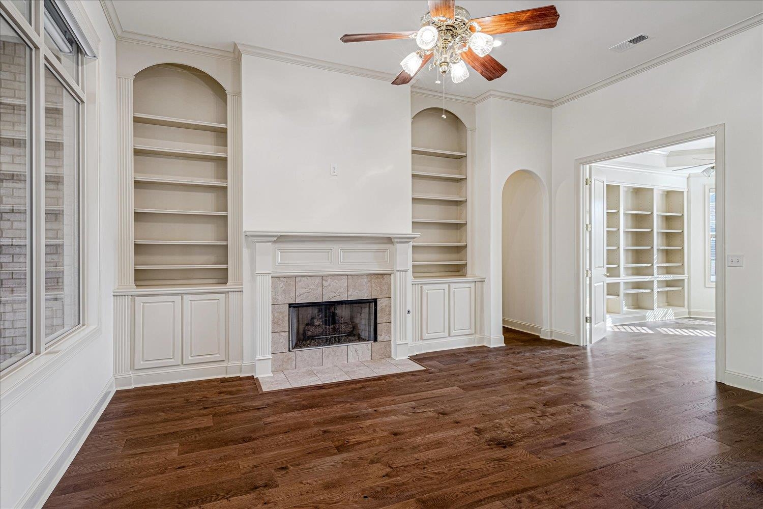 9178 Wilderridge Lane Memphis, TN 38018 - Photo 6 of 31 a view of an empty room with wooden floor fireplace and a window