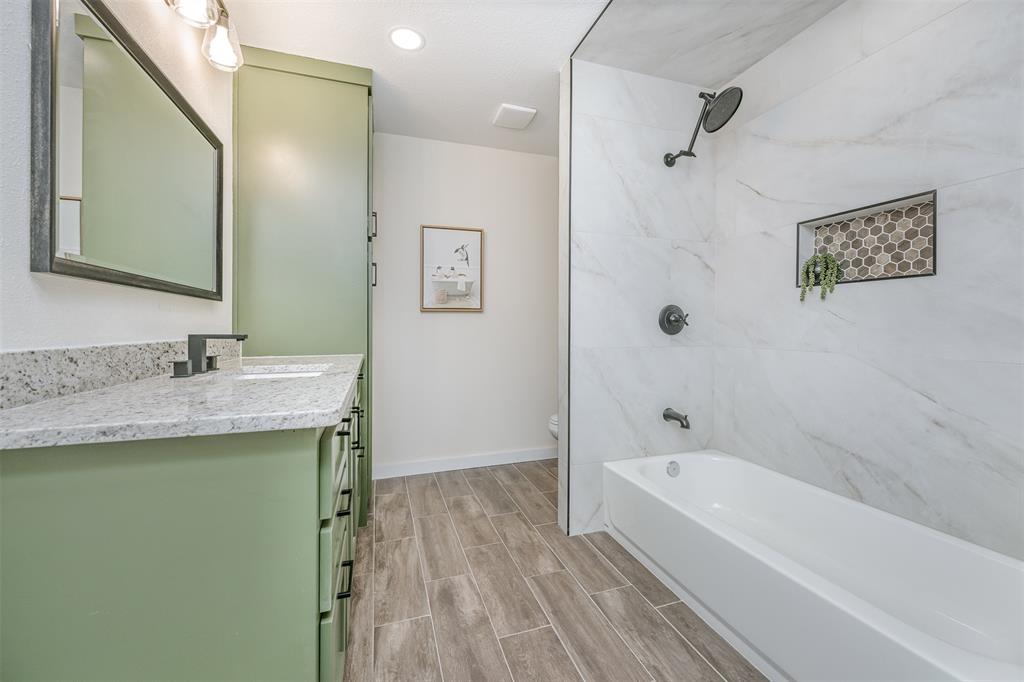 2006 Borger Plainview, TX 79072 - Photo 18 of 27 a bathroom with a granite countertop sink a mirror a shower and a bathtub