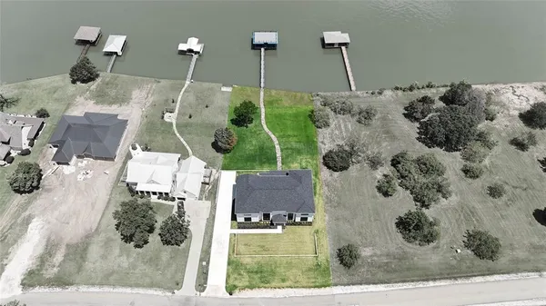 an aerial view of a house with a garden and lake view