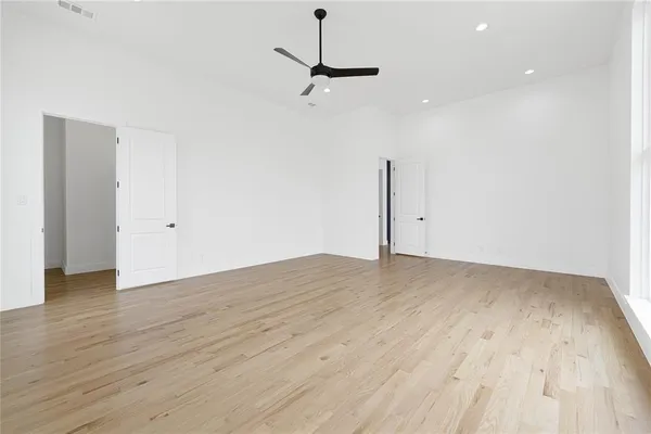 a view of a room with wooden floor and ceiling fan