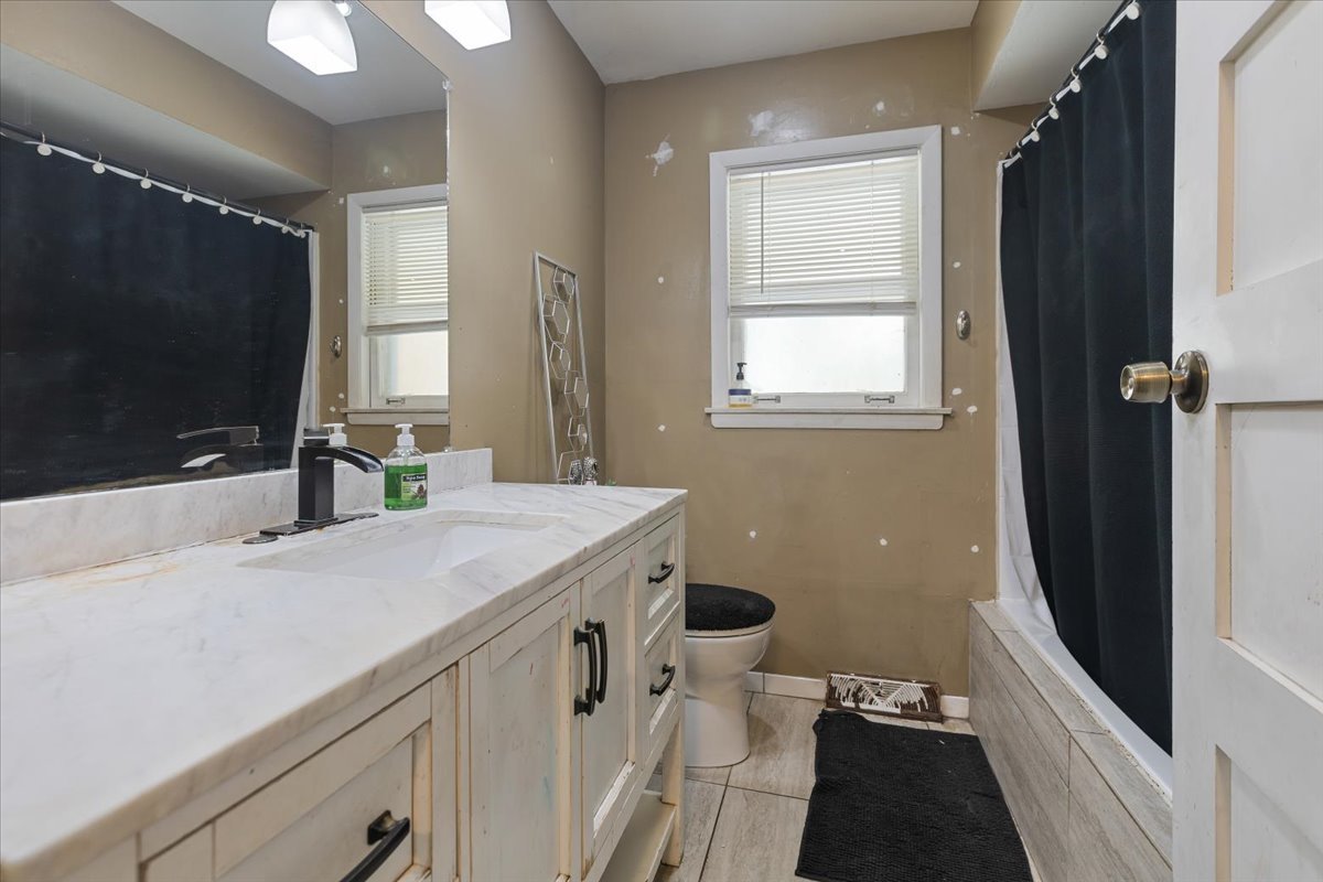 1246 Thomas Street Homewood, IL 60430 - Photo 13 of 29 a bathroom with a sink a toilet a mirror and window