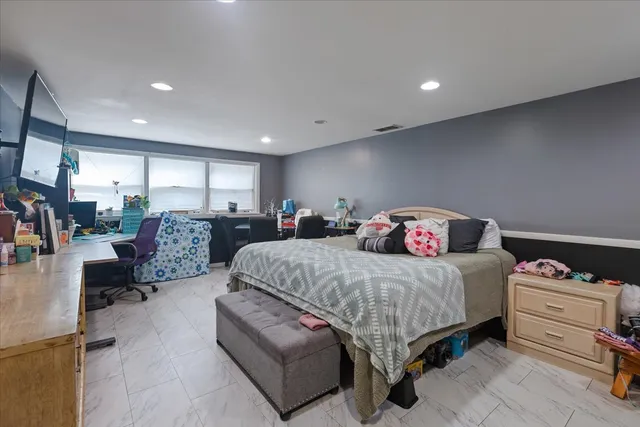 a spacious bedroom with a bed a couch and a view of kitchen