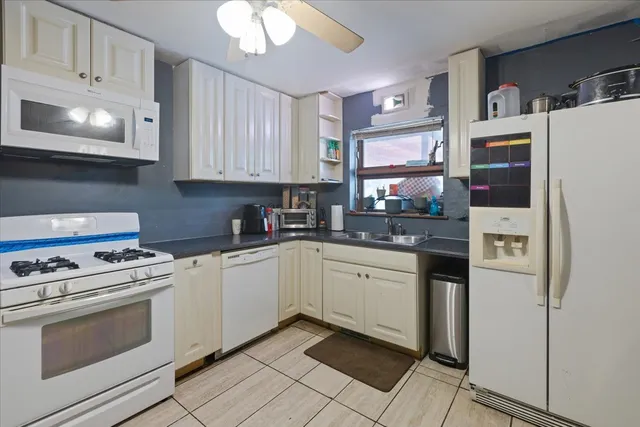 a kitchen with stainless steel appliances granite countertop a refrigerator a stove a sink and a microwave