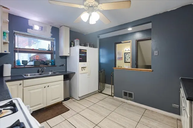 a kitchen with stainless steel appliances kitchen island granite countertop a refrigerator and a sink