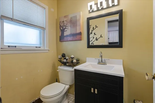 a bathroom with a toilet a sink and mirror