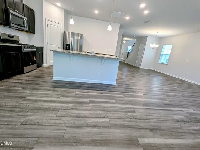 a metallic refrigerator freezer sitting in a kitchen