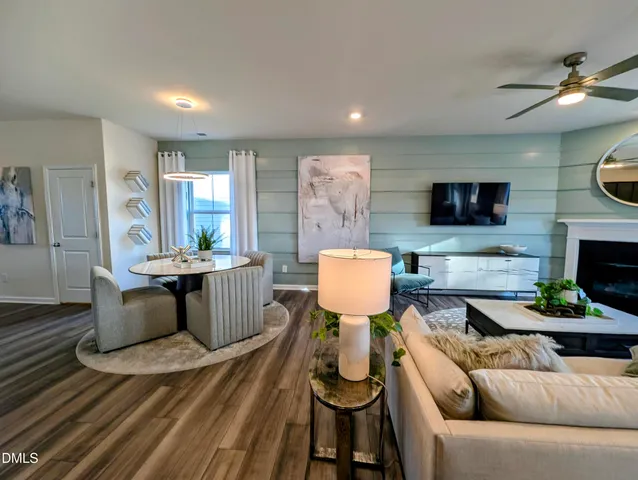 a living room with furniture a flat screen tv and kitchen view