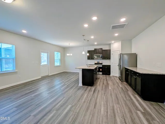 a view of a kitchen with wooden floor and a kitchen