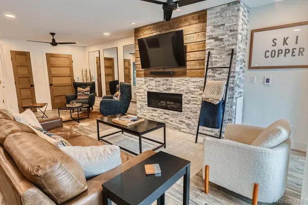 a living room with furniture a flat screen tv and a fireplace