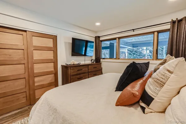 a bedroom with a bed and a flat tv screen