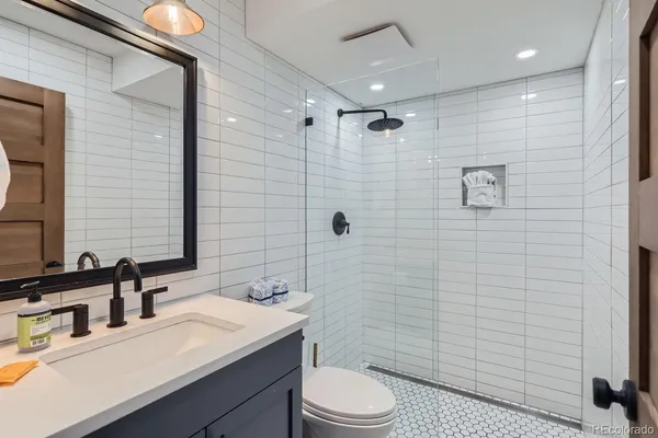 a bathroom with a sink a toilet and shower