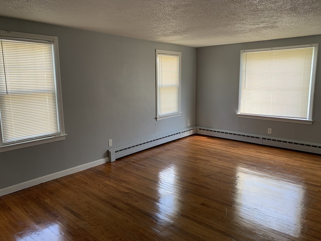 54 Fernald Street Springfield, MA 01109 - Photo 6 of 13 an empty room with wooden floor and windows