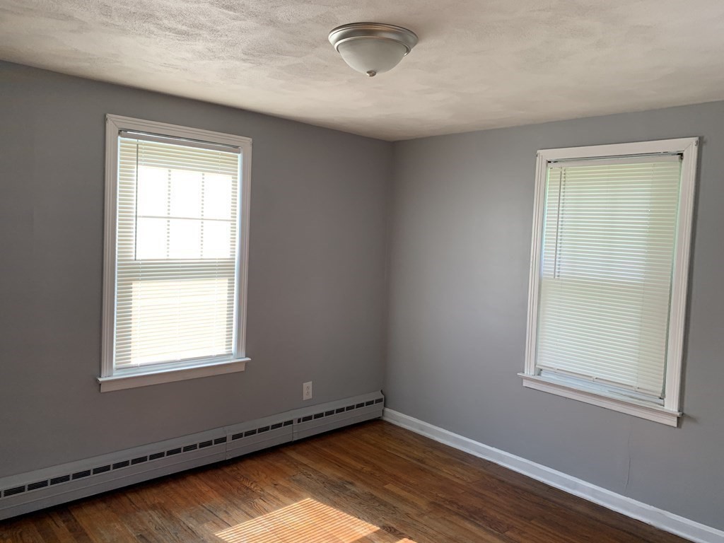 54 Fernald Street Springfield, MA 01109 - Photo 8 of 13 a view of an empty room with wooden floor and a window