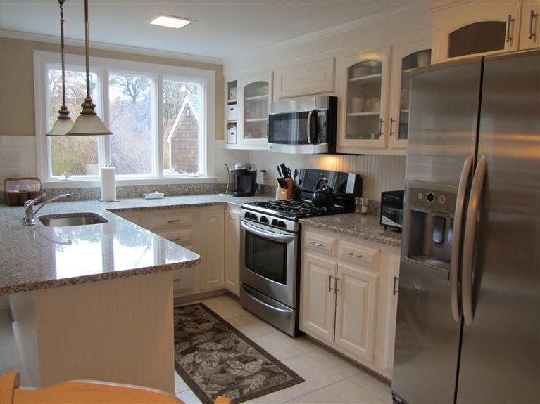 65 Bone Hill Road Barnstable, MA 02675 - Photo 16 of 34 a kitchen with stainless steel appliances granite countertop a refrigerator a stove and a sink with wooden floor