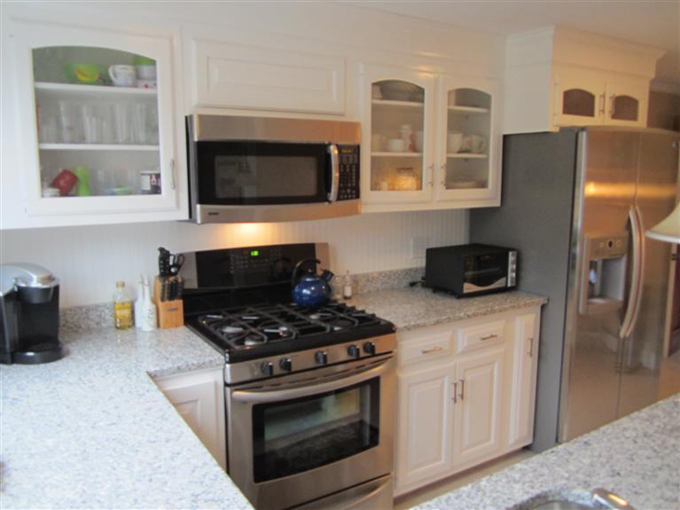 65 Bone Hill Road Barnstable, MA 02675 - Photo 17 of 34 a kitchen with stainless steel appliances granite countertop a stove a microwave and a refrigerator