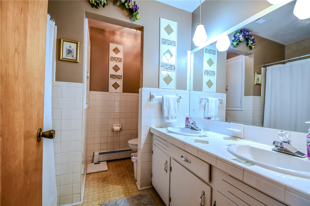 10833 Kendig Road Medway, OH 45341 - Photo 26 of 46 This bathroom offers dual vanities and tiled surfaces, providing both comfort and utility.
