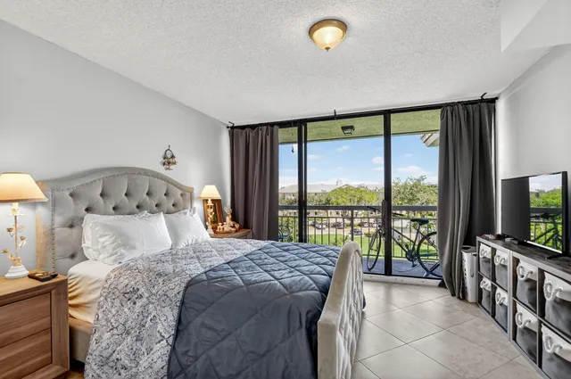 a bedroom with a large bed and a flat tv screen on dresser