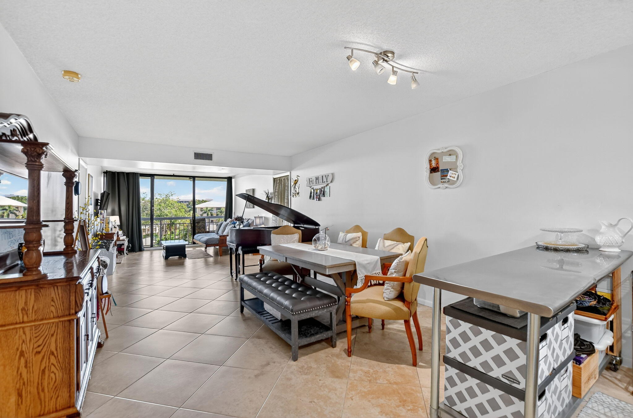 6205 Balboa Circle, Unit 403 Boca Raton, FL 33433 - Photo 5 of 41 a living room with a dining table and chairs with a bookshelf