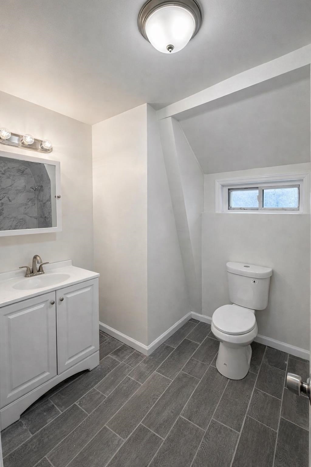64 South 13th Street, Unit 3 Newark, NJ 07107 - Photo 3 of 8 a bathroom with a toilet a sink and mirror