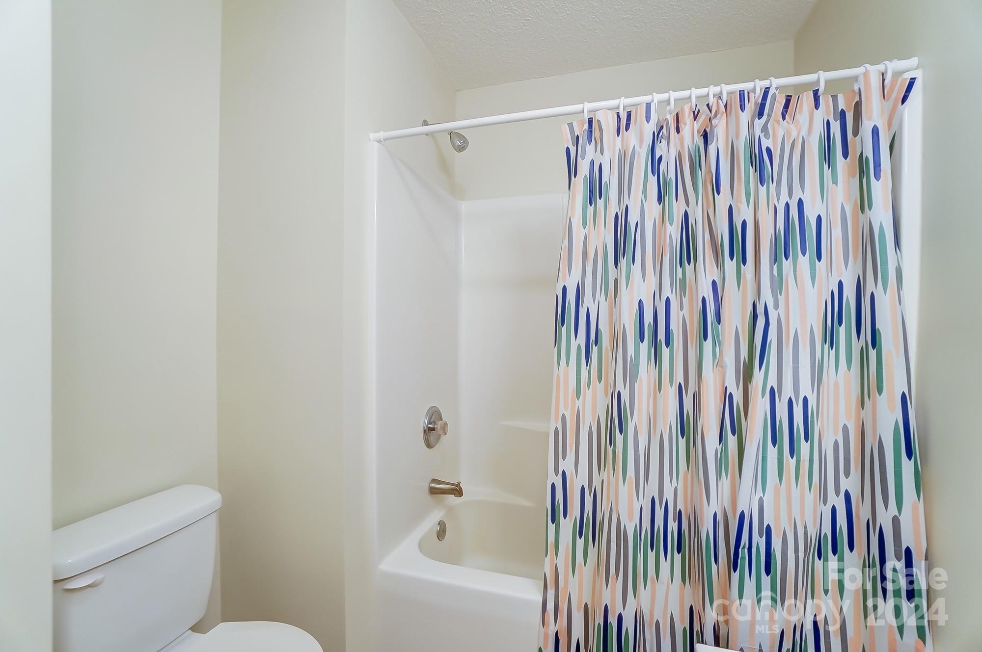 5312 Addison Road Waxhaw, NC 28173 - Photo 28 of 48 a bathroom with a shower curtain and a toilet