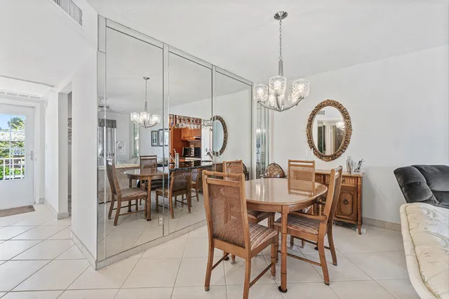 a view of a dining room and livingroom with furniture a chandelier and wooden floor