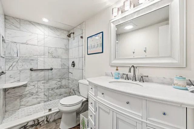 a bathroom with a sink a toilet and shower