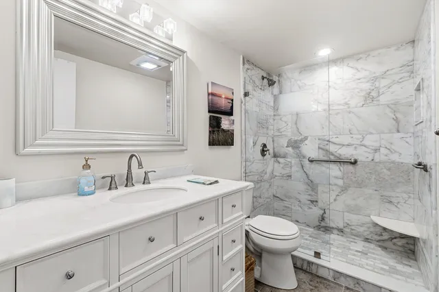 a bathroom with a sink a toilet and shower