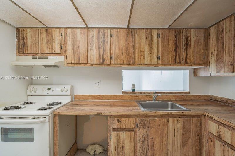 8540 Southwest 133rd Avenue Road, Unit 208 Miami, FL 33183 - Photo 16 of 18 a kitchen with a stove a sink and a cabinets