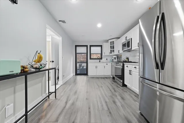 a kitchen with stainless steel appliances a stove refrigerator sink and cabinets
