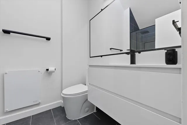 a bathroom with a toilet a sink and a mirror