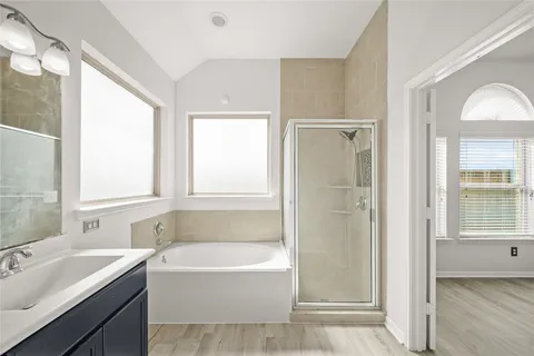 a bathroom with a tub sink shower and a mirror
