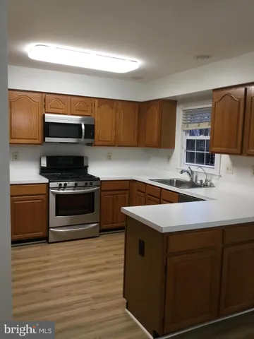 a kitchen with stainless steel appliances a refrigerator a stove a sink and a refrigerator