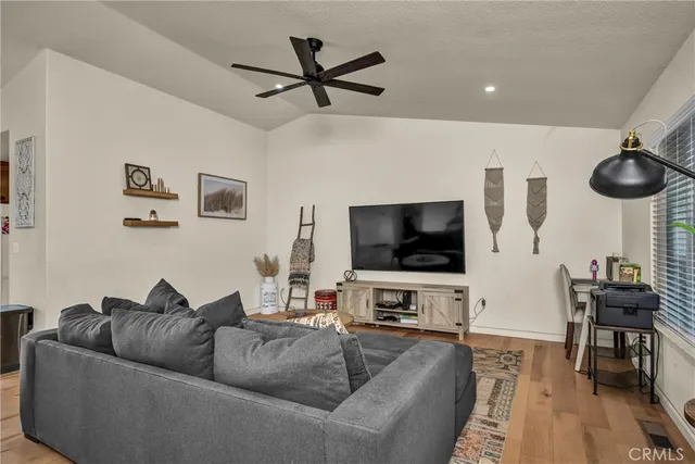 a living room with furniture and a flat screen tv with wooden floor