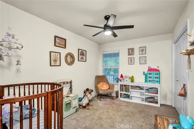 a bedroom with furniture a ceiling fan and a window