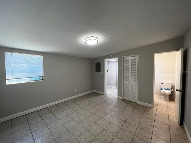 an empty room with windows and closet