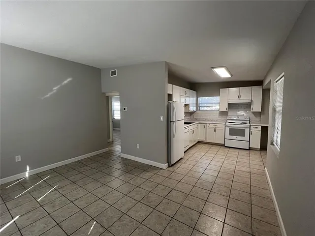 a kitchen with granite countertop a refrigerator and a stove top oven