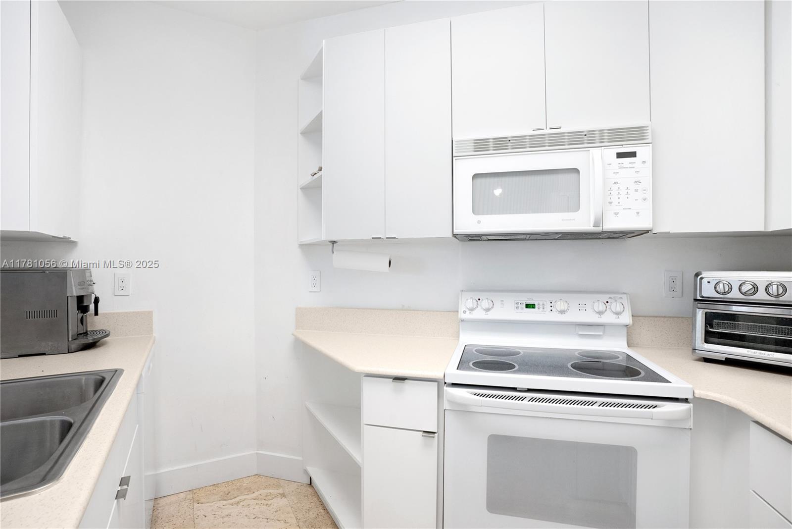 1 Century Lane, Unit 309 Miami Beach, FL 33139 - Photo 7 of 18 a kitchen with a stove and a microwave