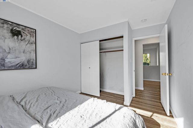 a bedroom with a bed and a painting on the wall