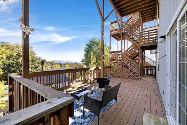 a balcony with wooden floor and outdoor seating