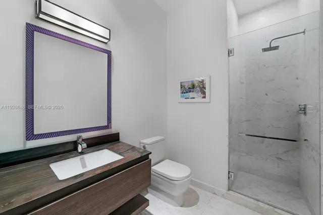 a bathroom with a granite countertop sink toilet and shower