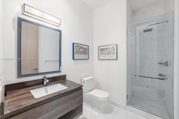 a bathroom with a granite countertop sink toilet a mirror and shower