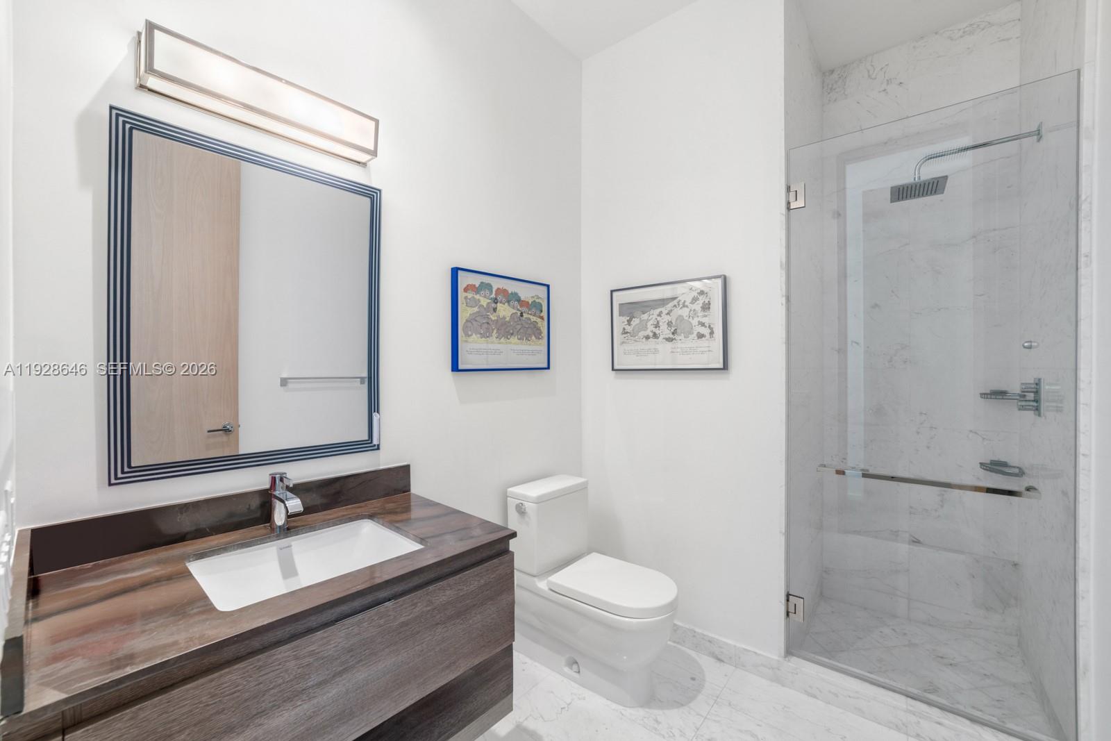 111 Reef Lane Key Biscayne, FL 33149 - Photo 19 of 26 a bathroom with a granite countertop sink toilet a mirror and shower