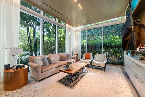 a living room with patio furniture and a floor to ceiling window